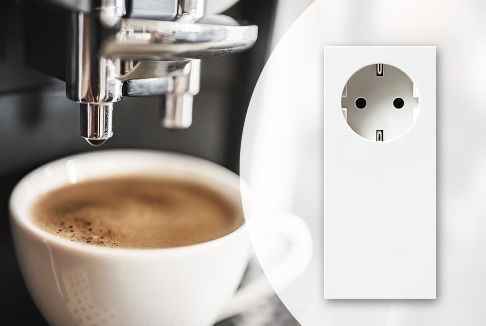 Ein Stecker für viele Möglichkeiten Kaffeetasse unter einer Kaffeemaschine. Rechts im Bild ist eine Steckdose abgebildet.