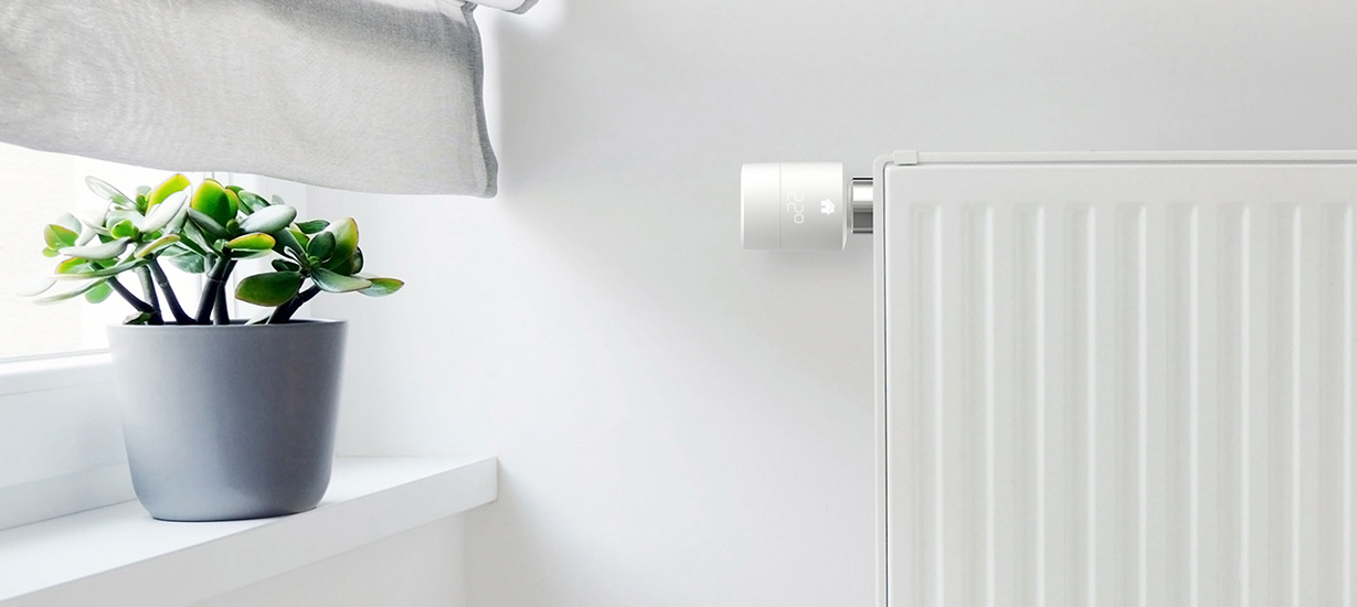 Heizkörper-Thermostat von tado° Pflanze auf Fensterbrett. Heizung mit Regler von eNET SMART HOME.